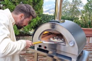 Pizza wordt met pizzaschep in Clementino gasoven geschoven