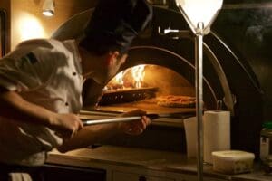 Pizzaoven in actie met echt e Italiaanse pizza bakker