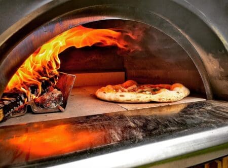 Family houtoven brandend vuur met pizza bakken