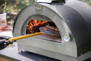 Clementino houtoven antraciet in werking, er wordt een pizza gebakken in de houtoven