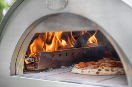 Close up beeld van Clementino houtoven met pizza en brandend vuur