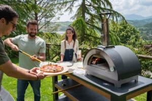 mesnen om de clementino houtoven met een pizza ie net uit de houtoven komt