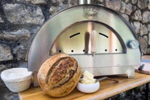 Clementino gasoven met versgebakken brood op houten tafel