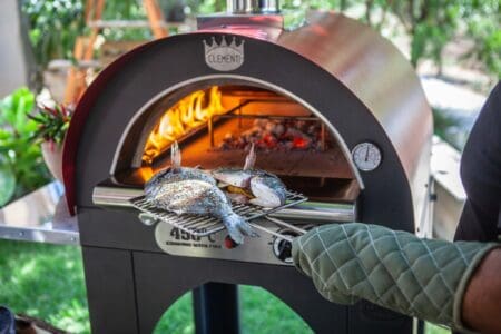 Vis grillen op een rooster in een Clementi houtgestookte pizzaoven