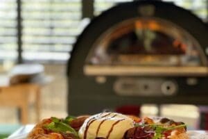 overheerlijke pizza burrata met gasoven op de achtergrond vervaagt