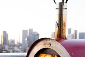 Rode Clementino gasoven op dakterras met vlam in oven