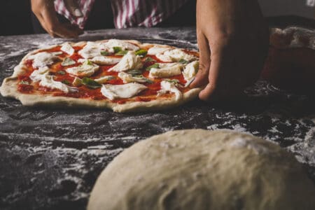 Pizza wordt in de oven geschoven