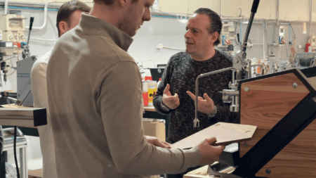 Dennis krijgt uitleg over een onderdeel van een ACS espressomachine